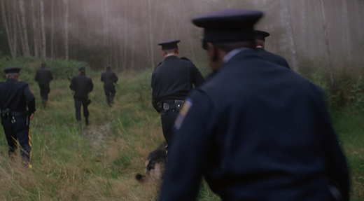 A group of police officers with guns and dogs hunt down the Jersey Devil.