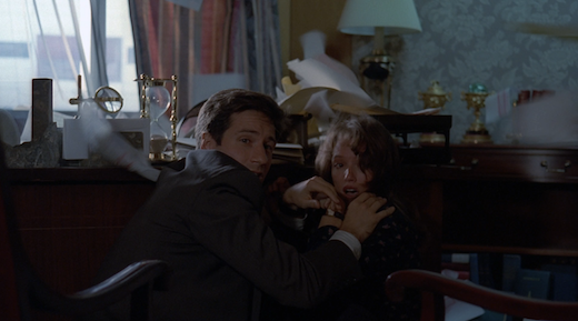 Mulder shields Lauren from papers flying all over the room.