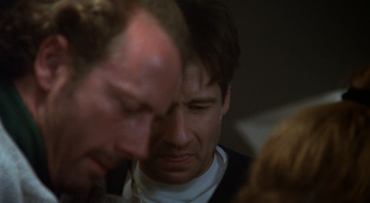 Mulder grimaces much like Scully at the grossness of Bear's infection.