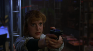 Scully points her gun at Mulder, her expression grim.