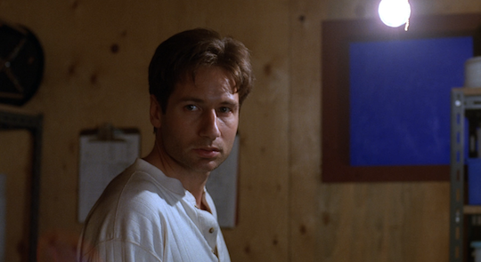 Mulder looks at Scully before she leaves him alone in a locked room.